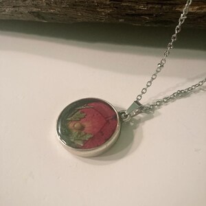 A "desert sunset" design from rose petals, pressed leaves, and mustard seed resin pendant jewelry on 20in satellite chain necklace jewelry